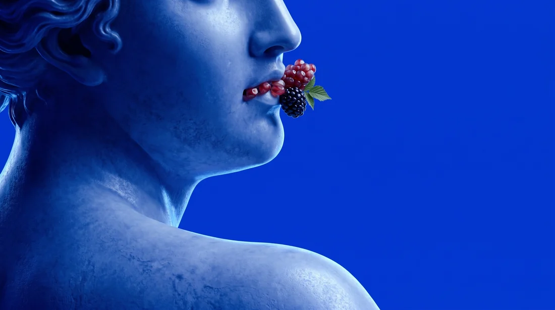 Blau-silberne Skulptur mit Beeren als surrealer Farbakzent.